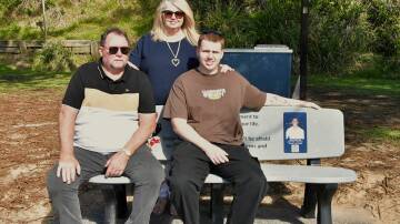 Darren (father), Leianne (mother) and Jack Moir (brother) sitting on the memorial bench for James Moir. Picture by Abi Kirkland