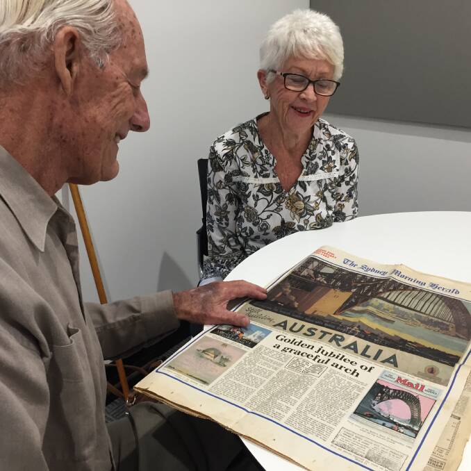 Bridge featured: Wauchope's Ron and Pam Dures looking over the 50th anniversary feature of the opening of the Sydney Harbour Bridge.