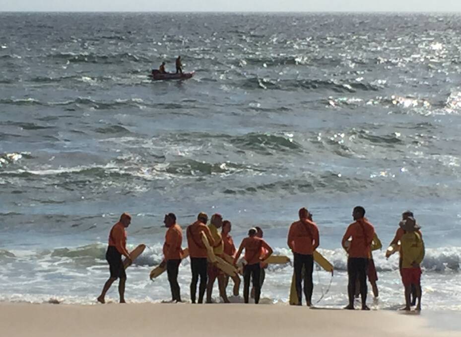 The search: Surf life saving volunteers recommencing the retrieval phase of their search for a missing 14 year old boy at Flynns Beach.