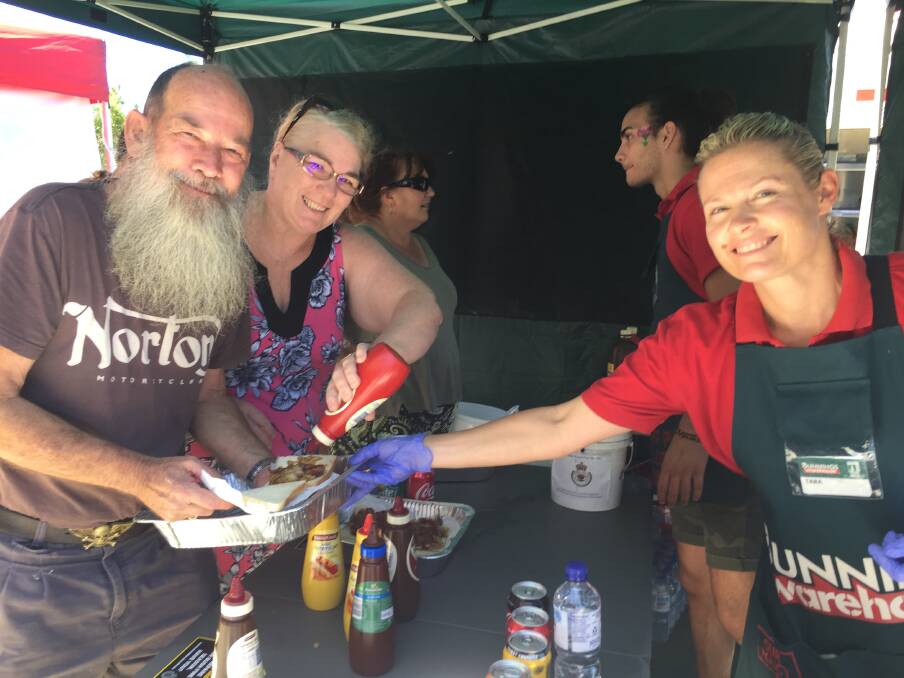 Here you go: Tara Mesiti serving up a sausage sandwich to Port Macquarie residents John and Carleen Pring.