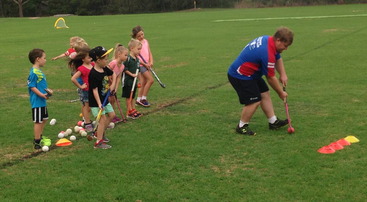 Look at me: Coach Colin Pursehouse teaches the four to seven-year-olds stick skills at the come and try day.