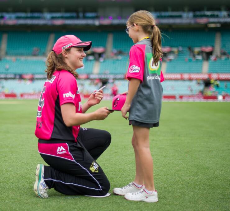 Sign your life away: Emily Leys signs a fan's hat at a recent Sydney Sixers fan function.