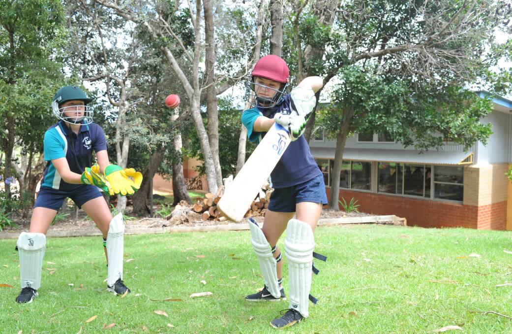 Eyes on the ball: Mia Fenton and Annalise Woodham will head to Maitland on Tuesday for the PSSA cricket finals. Photo: Paul Jobber