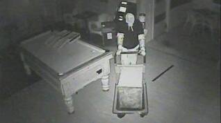 A CCTV still of the break-in. In this frame, the thief wheels the safe out on a trolley.