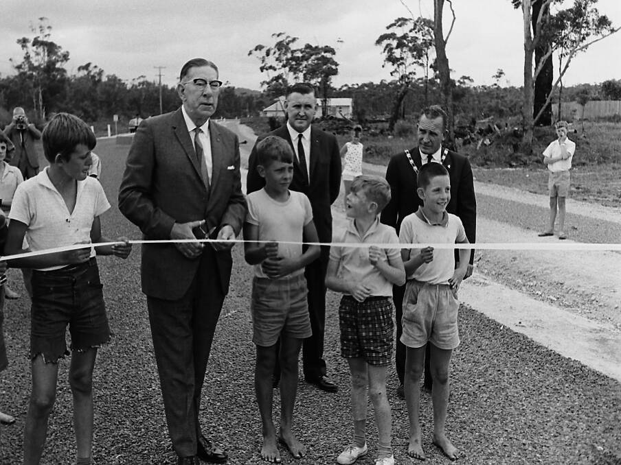 Ocean Drive: The Commissioner for Main Roads, Mr Shaw, helped by some young supporters, cuts the ribbon to open another stretch of the Coast Road, 1966