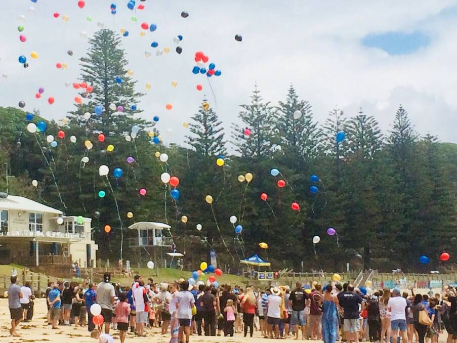 Final farewell: Family and friends gather at Flynns Beach to farewell Bronson Rhodes. Photo: Supplied.