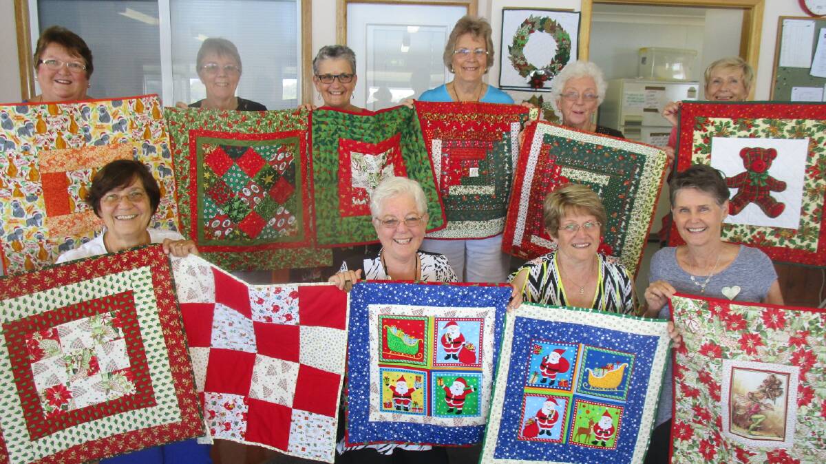 With some of the handmade quilts destined for newborns at Port Macquarie Base Hospital this month are (back, left to right) Judy Kilkeary, Lyn Wilkinson, Dawn Lane, Annette Mangold, Gwynith Perry, Val Dorahy, (front, left to right) Pat Davis, Sue Morton, Lorraine Clancy and Jill Pierse.