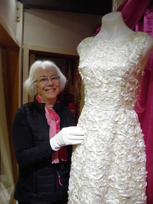Anne Oud installs the ribbon embroidered lace wedding dress worn by Susan Baldwin (nee Medaris) in 1965. The Passion for Fashion exhibition features classic dress and special occasion wear, accessories and photographs from the 1960s. 