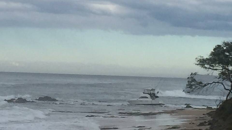 Stranded: Four people made it to shore uninjured after their boat became stranded on rocks at Middle Rock, Lake Cathie. Photo: Todd Taylor.