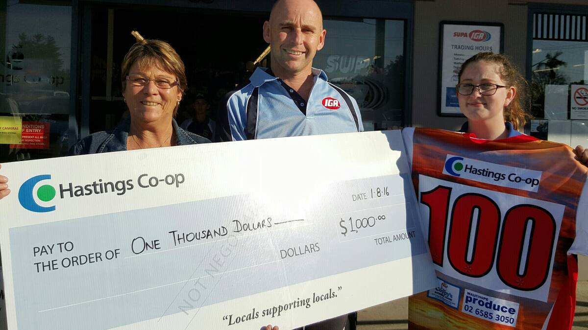 Long Flat RLFC representatives Kate Mumford (left) and Bek Trotter receive their grant from Wauchope IGA manager Darren Partridge.