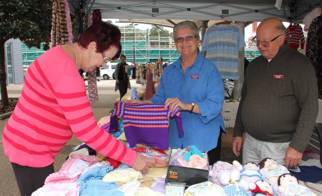 Hospital Volunteers Margaret Bradley and Roger Adams assist a customer with a special gift selection at last year’s Lake Innes Shopping Centre stall.