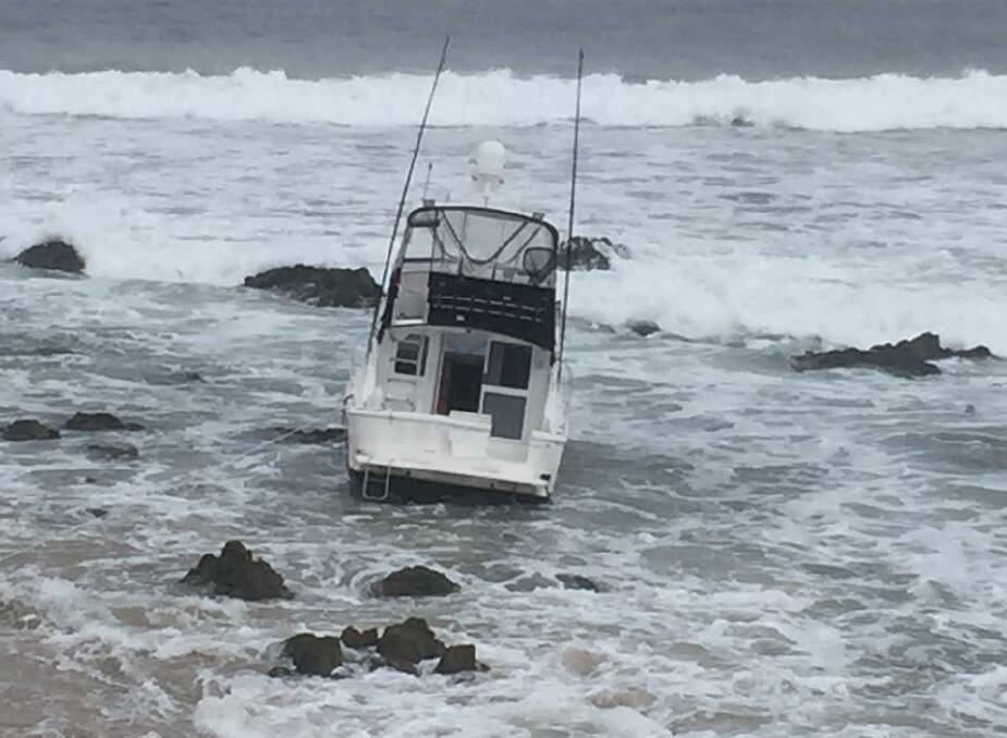 Stranded: Four people made it to shore uninjured after their boat became stranded on rocks at Middle Rock, Lake Cathie. Photo: Todd Taylor.