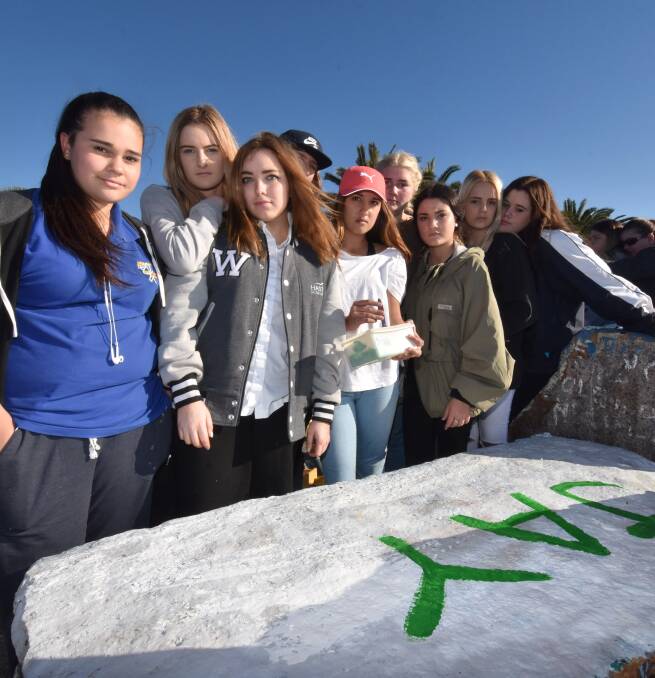 Friends gathered on Town Beach breakwall on Tuesday to paint a rock in honour of their friend Jay Reynolds
