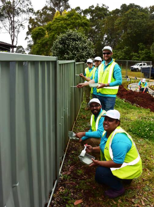 Park transformation: Lendlease staff members Trista Taylor, Drew Cooper, Will Verco, Kieran Metcalfe and Josie Roper paint a fence at Oxide Park.