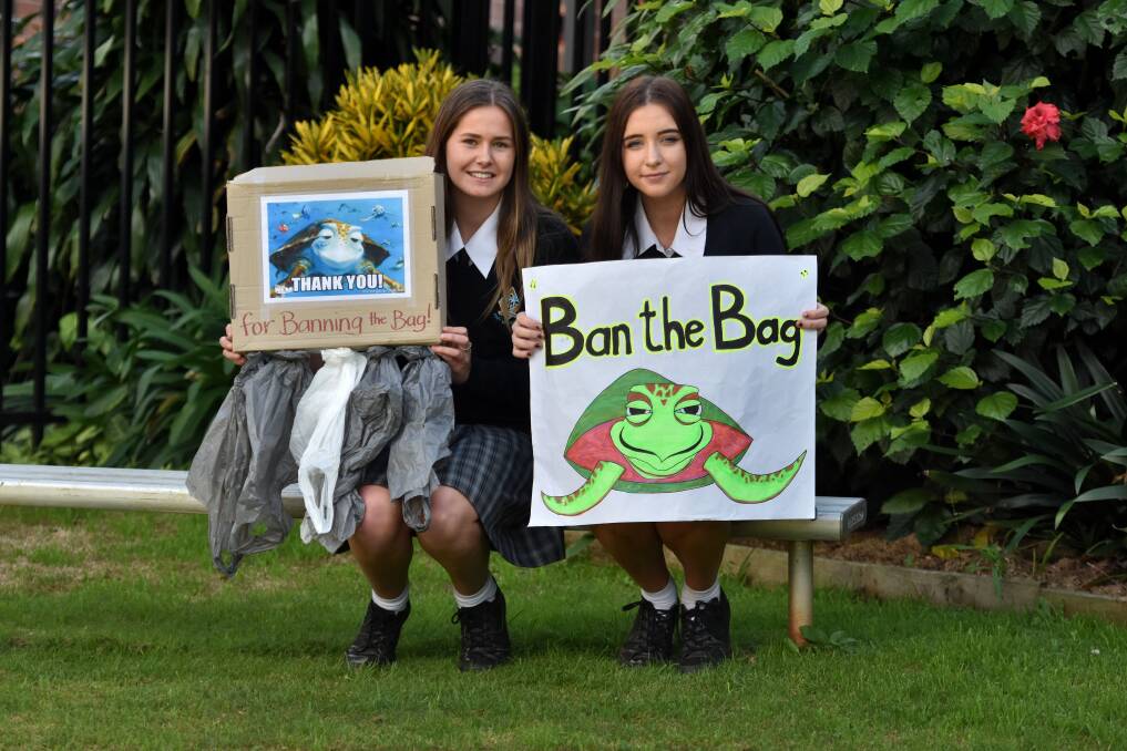 Taking action: MacKillop College students Amelia Humphreys and Niamh de Groot encourage people to reject single-use plastic bags.