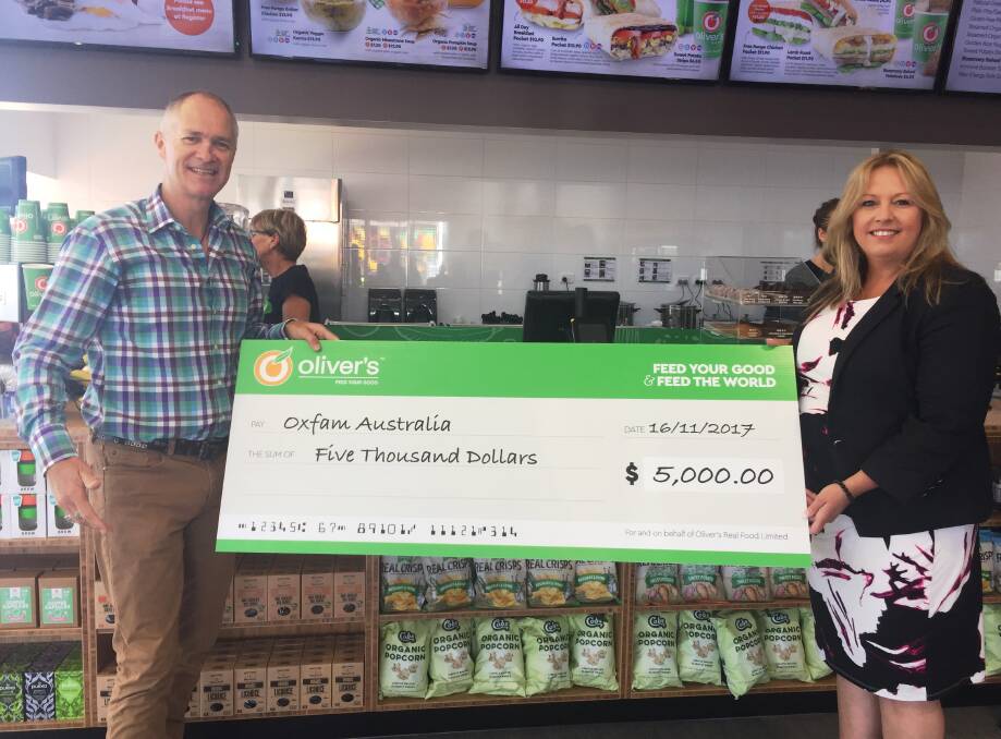 Oliver’s Real Food founder and CEO Jason Gunn and mayor Peta Pinson with the $5000 cheque for Oxfam.