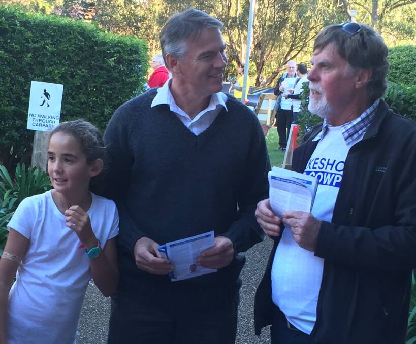 Busy day: Independent candidate for Cowper Rob Oakeshott, with his daughter Olivia by his side, talks to campaign volunteer Terry Robinson on election day. Mr Oakeshott visited polling booths across the electorate.