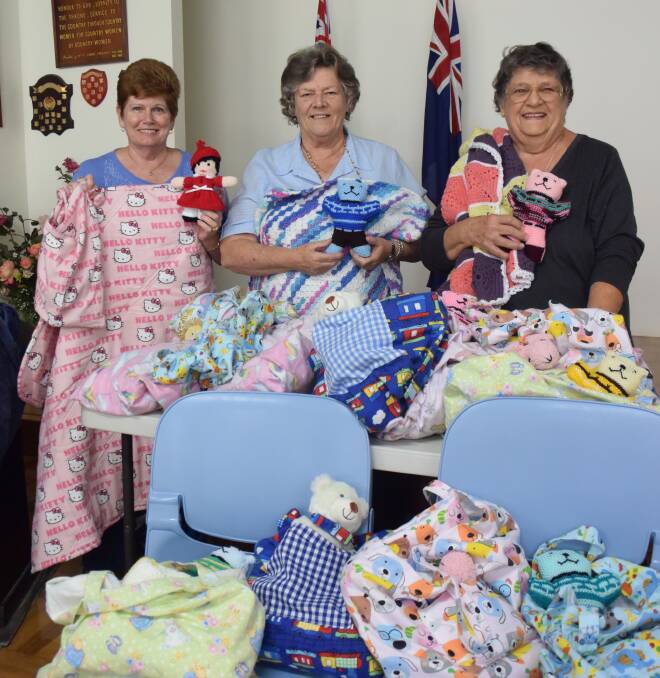 Thoughtful donation: Lyn Elliott, Marilyn Brown and Margaret Wilson get the bags, rugs and soft toys ready for donation.