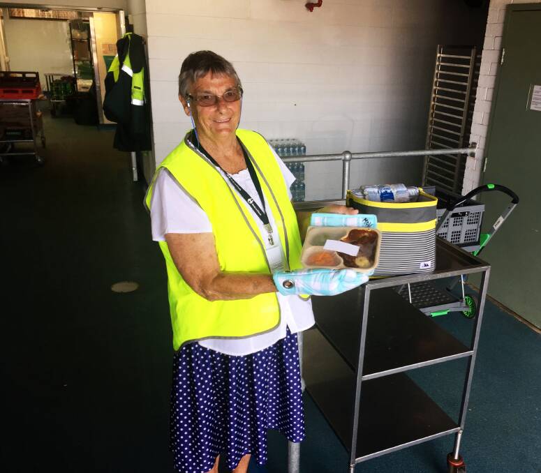 Volunteer effort: Port Macquarie Meals on Wheels volunteer and OAM recipient Helen Guthrie prepares to deliver a hot meal at Garden Village.