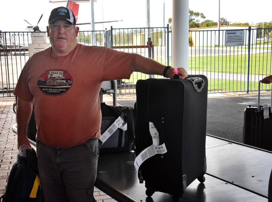 Luggage lift: Mick Humphries collects his bag from the luggage trailer at Port Macquarie Airport. Improved baggage claim facilities are part of the airport terminal building upgrade plan.
