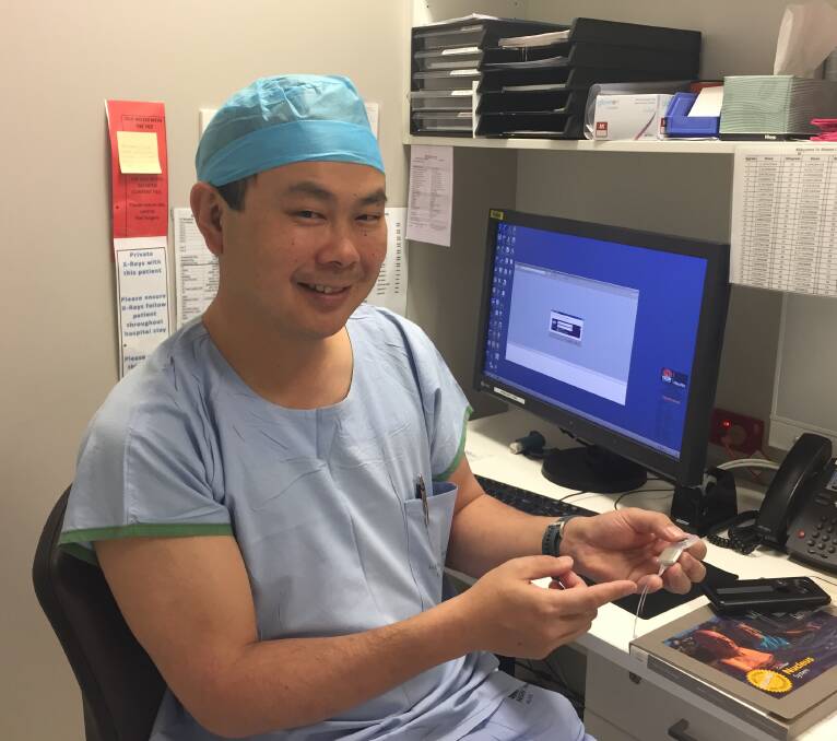 Ear and cochlear implant surgeon Dr Jonathan Kong displays the internal component of a cochlear implant.