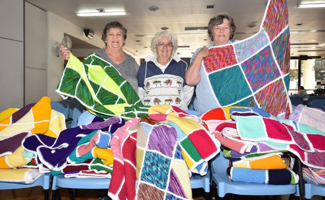 Knitted warmth: Port Macquarie CWA Branch assistant craft officer Margaret Wilson, visitor Gloria Hedrick from Macksville CWA and craft officer Marilyn Brown display the rugs. Photo: Ivan Sajko