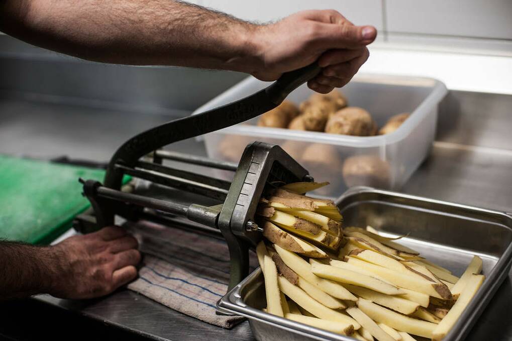 For pomme frites: 1. Wash the whole potatoes but do not peel them. Step 2. Cut with a potato punch, or use a knife to cut 1.5cm thick chips. Photo: Josh Robenstone/Getty Images