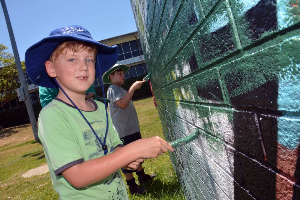 Graffiti buster: Even 7-year-old Isaac Freeman knows there is no excuse for the vandalising of public property and puts his brush to good work covering it up at the Hasting Valley Netball clubhouse yesterday.