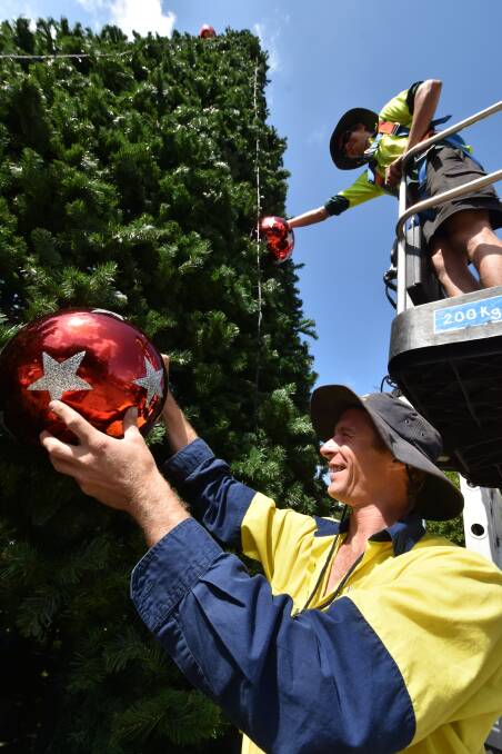 Getting into the spirit of things: Evan Lansdowne and Cameron Chick placing baubles on the town's Christmas tree.  
Pic: NIGEL McNEIL