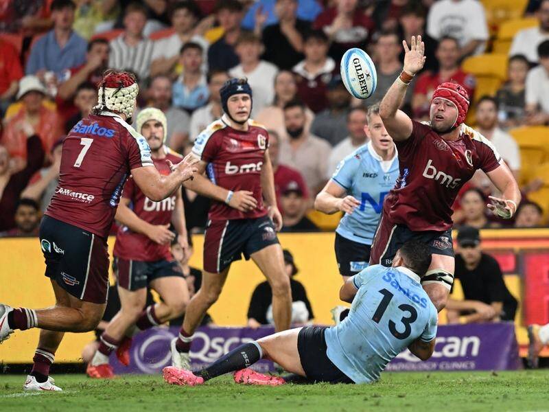 Harry Wilson (right) passes to Reds teammate Fraser McReight (left) against the Waratahs. (Darren England/AAP PHOTOS)
