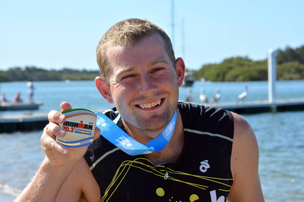 All smiles: Bennett Powell with his finishing medal after Sunday's Ironman 70.3.                                        Pic: PETER GLEESON