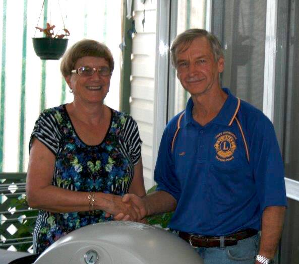 Raffle winner: Lorraine Best receives first prize from Tacking Point Lions Club President Lion Al Philp.