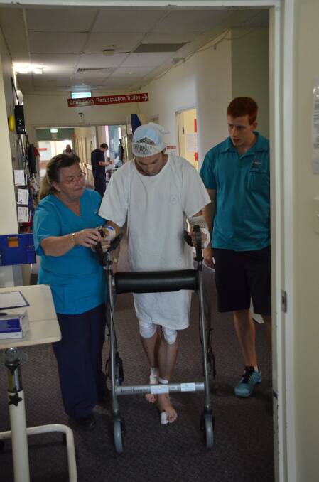 Small steps to start: Physiotherapy assistant Sally Simonetta and physiotherapy technician Mitchell Olsen watch Michael Baldwin's progress yesterday.
