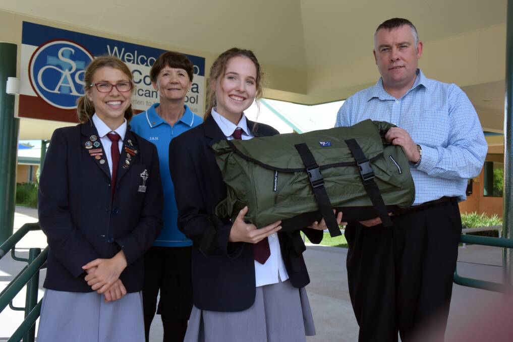 A worthy cause: St Columba Anglican School captain Madeleine Brown and interact president Emma Dennis present New Horizons representative Darryl Barleycorn and Rotary Sunrise Port Macquarie member Jan Crombie with a swag to help the homeless.