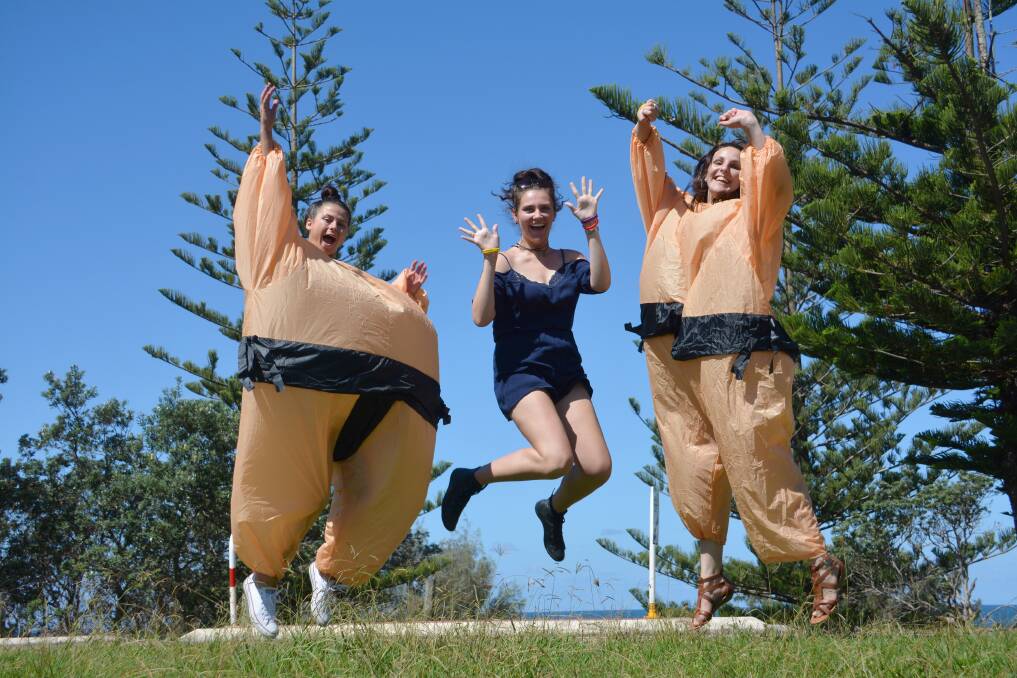 Social activities: Charles Sturt University Port Macquarie Campus first year students Nicole McKellar (left) and Nicole Liokos (right) don sumo suits for the CSU amazing race during Orientation Week, with support from fellow first year student Michaela McLeod.