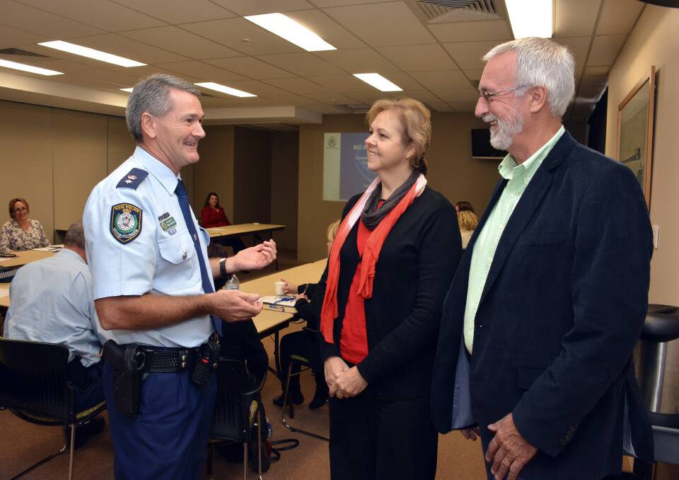 Finding solutions: Superintendent Paul Fehon discusses illegal graffiti and other crimes with the neighbourhood centre's Julie Trowbridge and Graeme Cunynghame from Pripol Forensic at Tuesday's meeting.