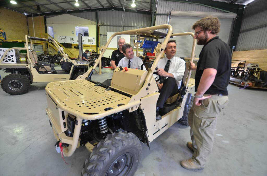 Ready to roll: Bale Defence's technical writer Mike Brownlow keeps an eye on things as Dr David Gillespie MP and Darren Chester MP are taken through the technical specifications of a new RTV by Bale's project engineer Link Bale.