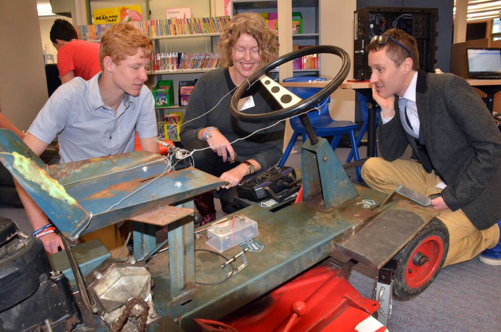 Creative minds: SCAS year eight student Zac Stewart discusses his remote controlled lawnmower with workshop leaders Kate Booth and Joachim Cohen at Monday's expo before the computational thinking conference.