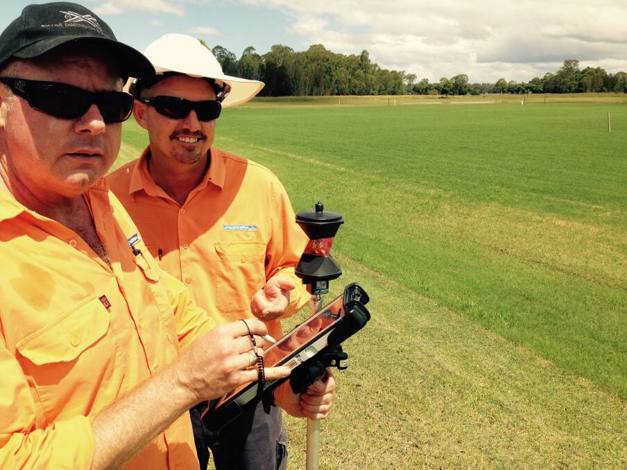 Checking the data: Pacific Survey's Mark Bryant and Mat McGuire checking instruments prior to marking out the new playing pitch at Football Mid North Coast headquarters at Telegraph Point on Wednesday.