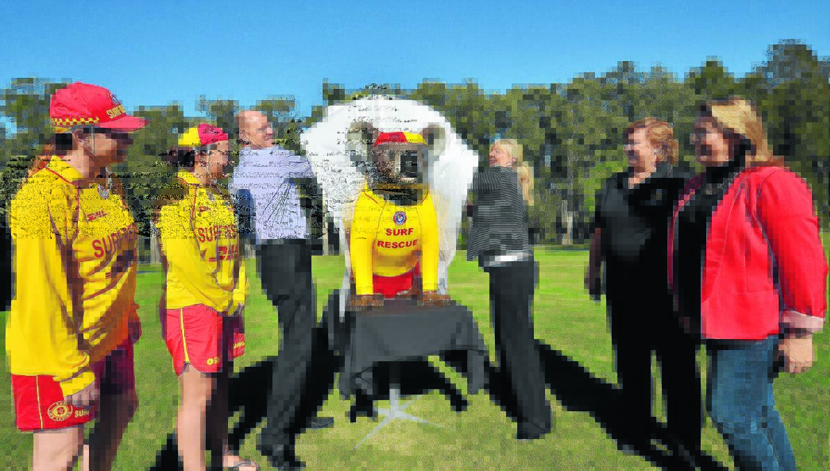 Great swimmer: McDonald's Port Macquarie owners Brett and Jacqui Jones unveil Mac the surf life saving koala with members of Port Macquarie Surf Life Saving Club from left, Stephanie Ruddy, Jess Rayner and vice president of the club Kim Rayner as artist Pauline Roods stands by.