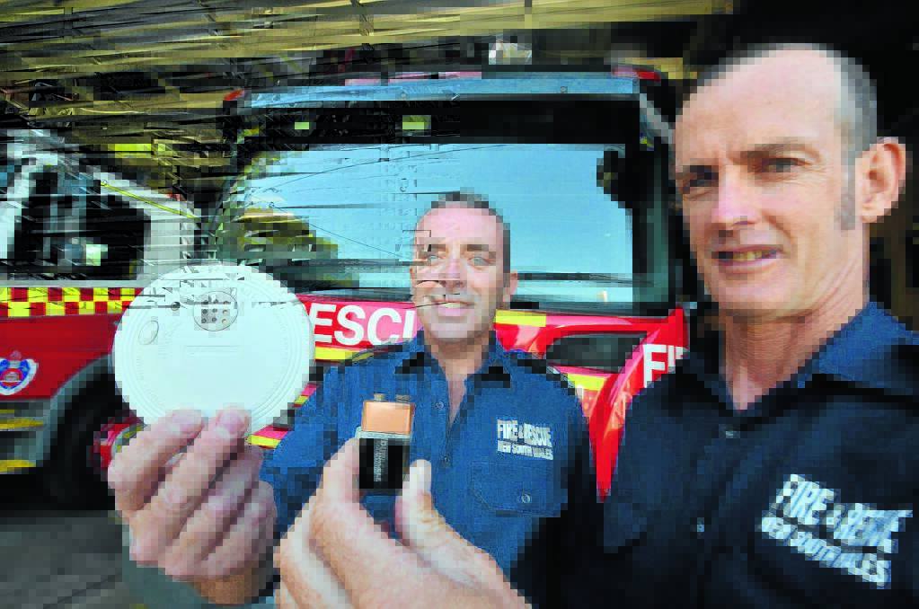 Saves lives: Port Macquarie Fire Station officer Geoffrey Peacock and senior firefighter Craig Stevenson replace the battery in a smoke alarm.