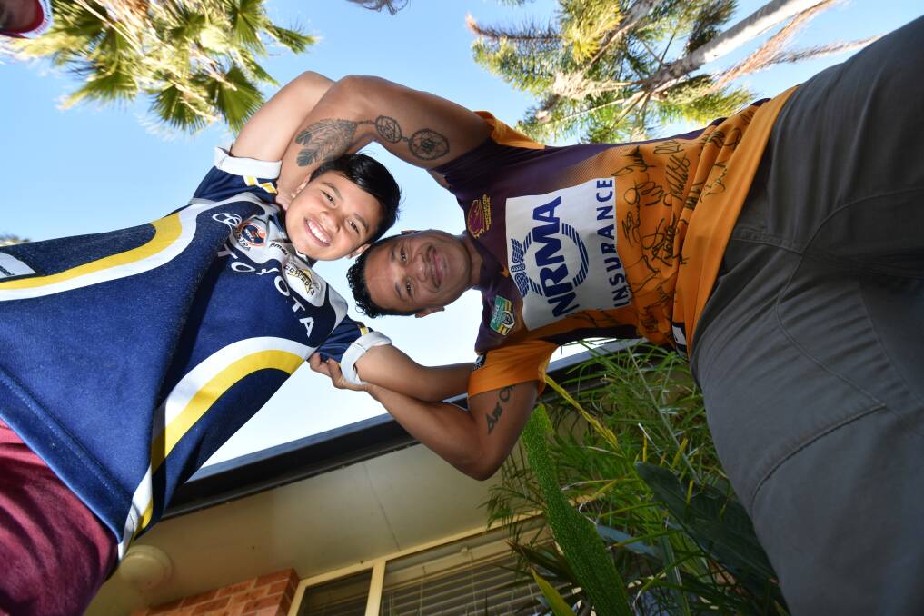 Father, son rivalry: Deon Glassie with son Kaia. They will go head to head on Sunday when their favourite teams battle it out in the NRL grand final. Photo:?NIGEL McNEIL