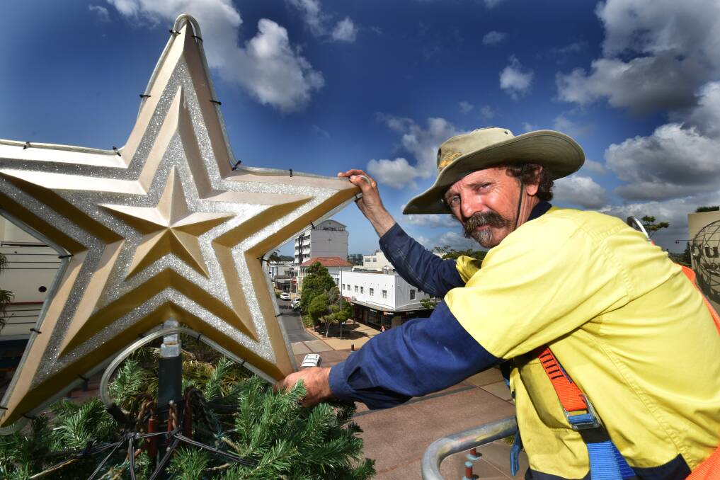 Getting into the spirit of things: Rodney Geering places the star atop the town's Christmas tree. Pic: NIGEL McNEIL