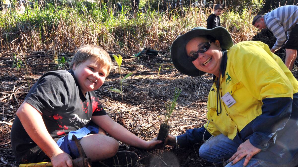 Dirty work: Brock Bermingham and his mum Danielle get their green thumbs working to plant a tree on National Tree Day thanks to Holiday Coast Credit Union's donation.