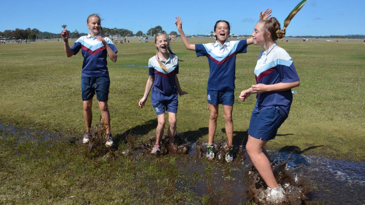 Soaking it up: St Columba students Stephanie Nelson, 
Jayda Hoole, Gabriella Caldwell and Lilli Buckridge celebrate the sun at the touch football gala day in Port Macquarie yesterday.
Pic: PETER GLEESON