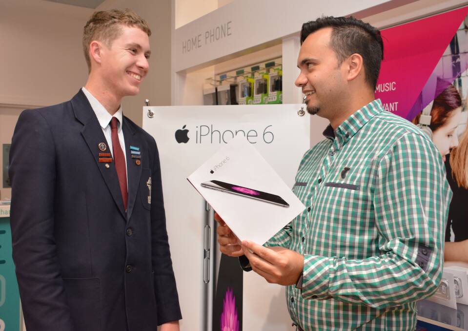 Lining up for a new iPhone 6 is Tim Hitchins with Telstra Port Central manager Matt Lawton.