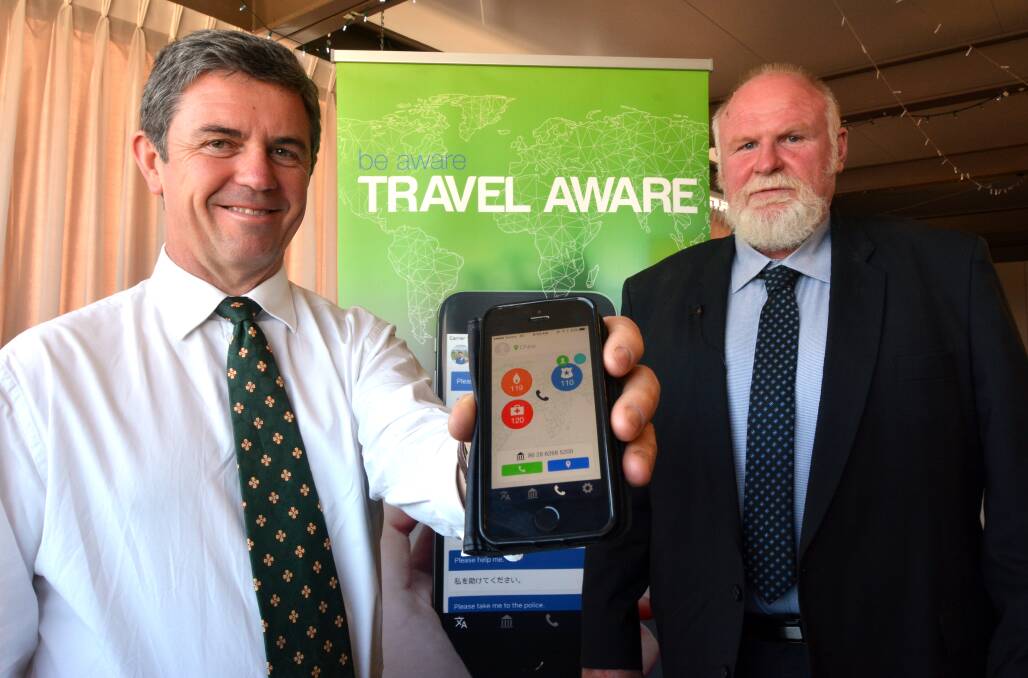 Travel aware: Dr David Gillespie and Neil Wallace with the new phone app which enables travellers to contact emergency services around the world with a push of a button.