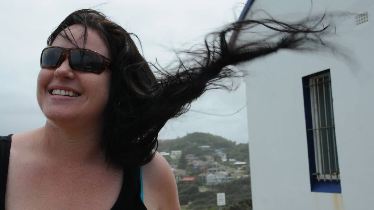 Kym Blake cops the brunt of the wind at Tacking Point Lighthouse on Monday. 