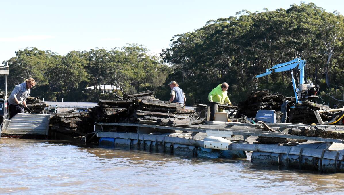 The wash-up: Oyster farmers gather to assess their losses this week. Photo: MATT McLENNAN