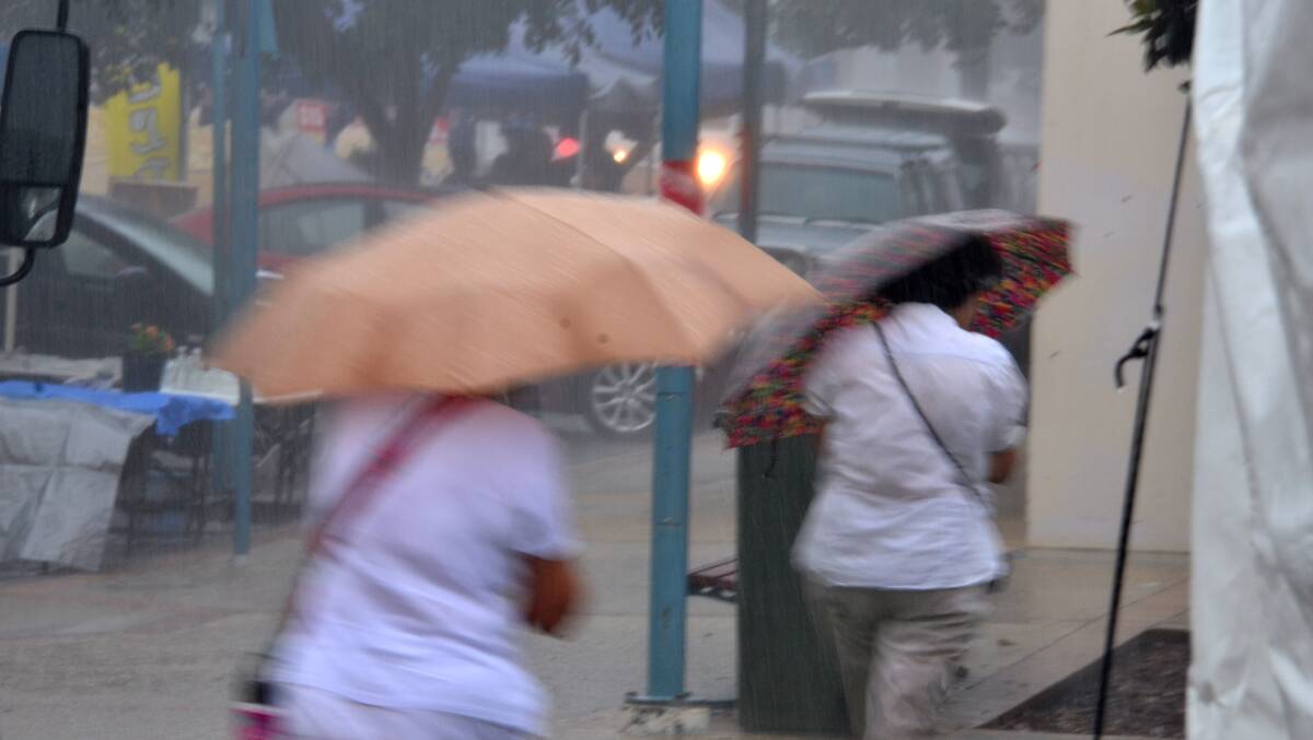 Brollies might be enough: pedestrians shelter in the middle of a severe thunderstorm warning on Monday. Pic: NIGEL MCNEIL